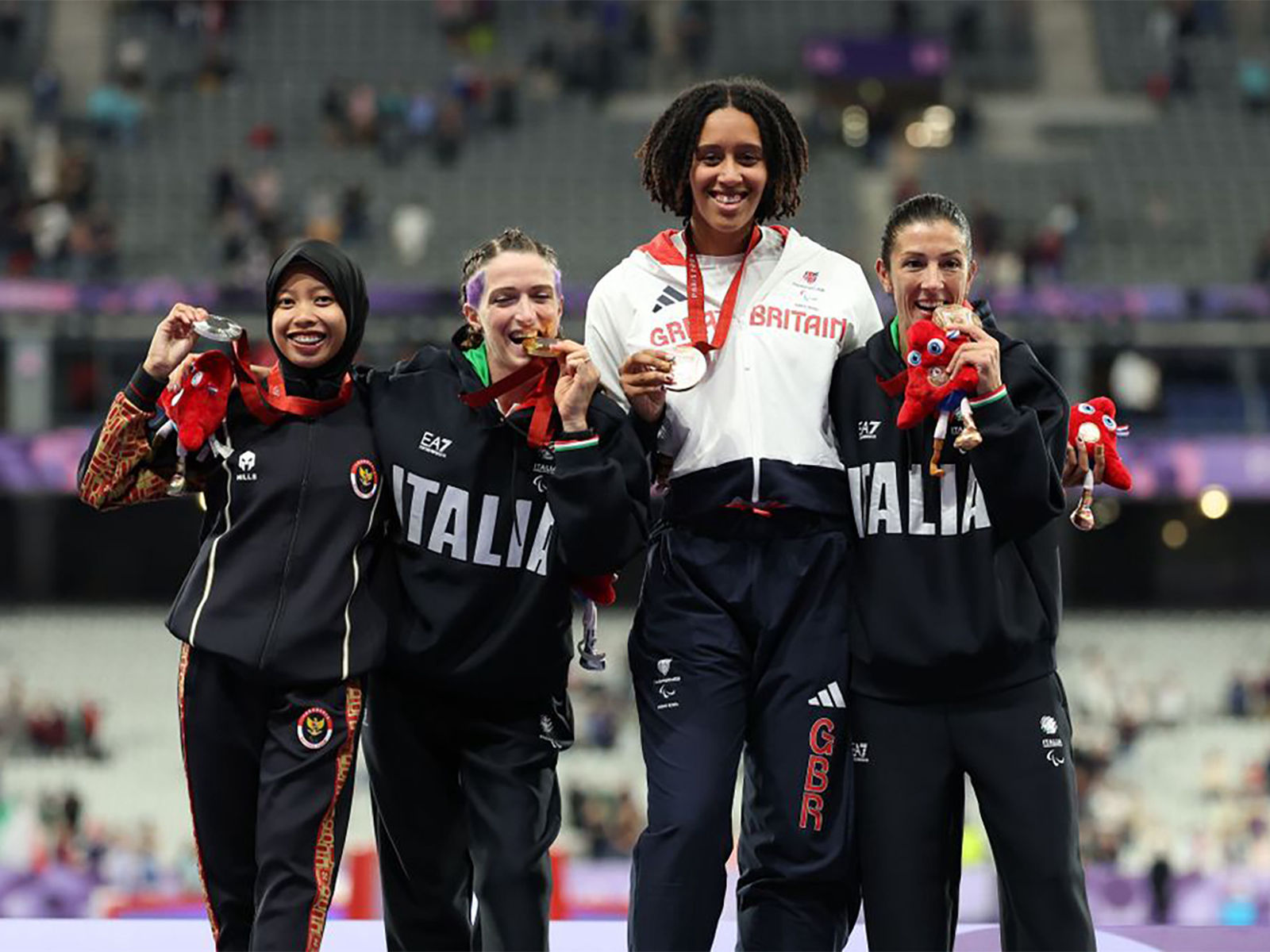 Silver medalist Karisma Evi Tiarani of Team Indonesia, Gold medalist Martina Caironi of Team Italy, and joint Bronze medalists Ndidikama Okoh of Team Great Britain, and Monica Graziana Contrafatto of Team Italy pose for a photo during a medal ceremony for the Women's 100m- T63 Final on day ten of the Paris 2024 Summer Paralympic Games at Stade de France