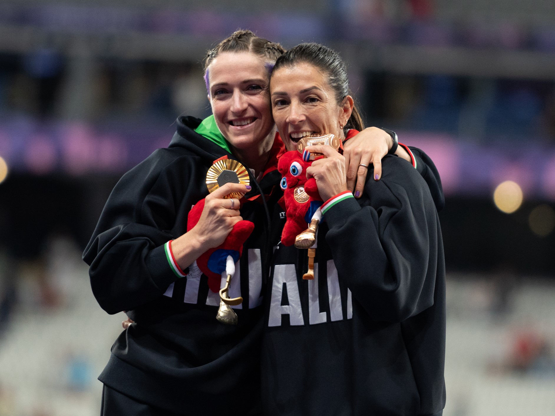 Martina Caironi and Monica Contrafatto react on the podium of Women's 100m - T63 Final at Stade de France during the Paris 2024 Paralympic Games in Paris
